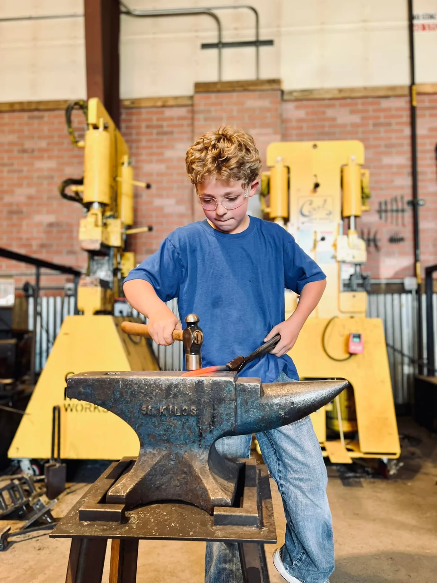 Student shaping metal at an anvil in the Colorado Trades Academy workshop